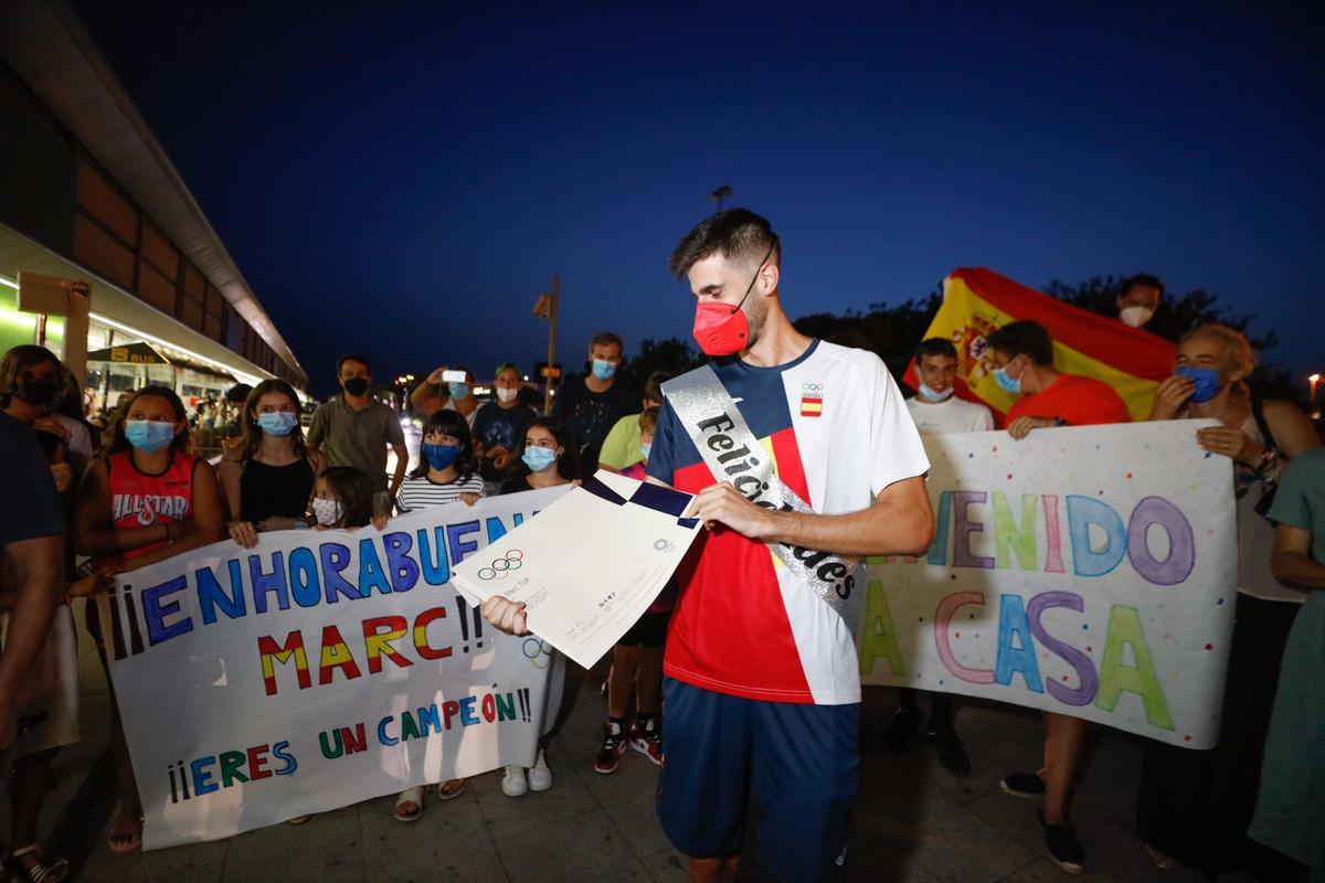Marc Tur, rodeado de familiares, amigos y aficionados de la isla, muestra el diploma olímpico conseguido en los 50 km marcha.