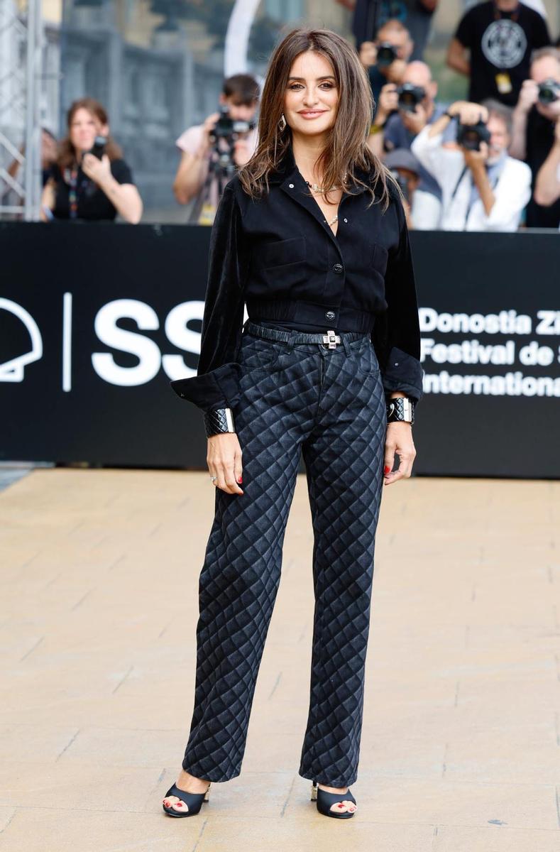 Penélope Cruz con camisa negra y pantalones caleidoscópicos