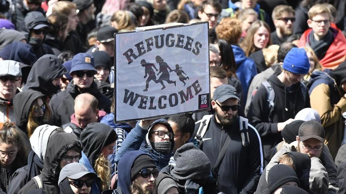 Manifestantes sostienen una pancarta de bienvenida a los refugiados, en una marcha en Colonia.