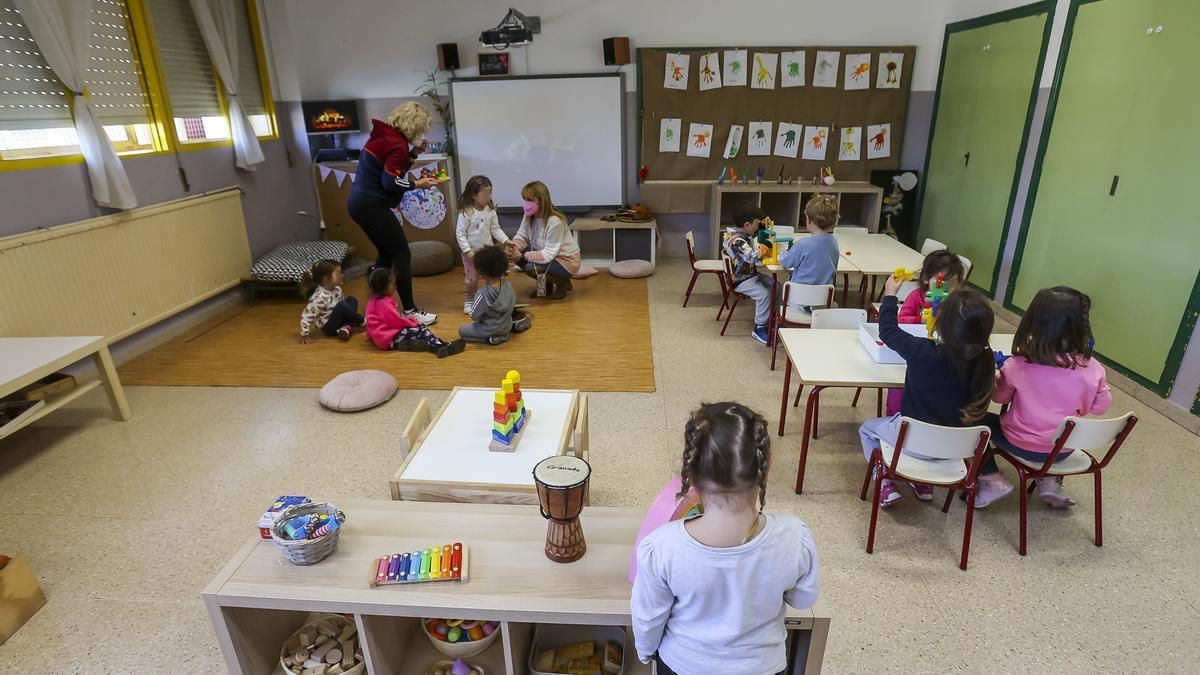 Profesionales educativos trabajan con alumnos en una clase.