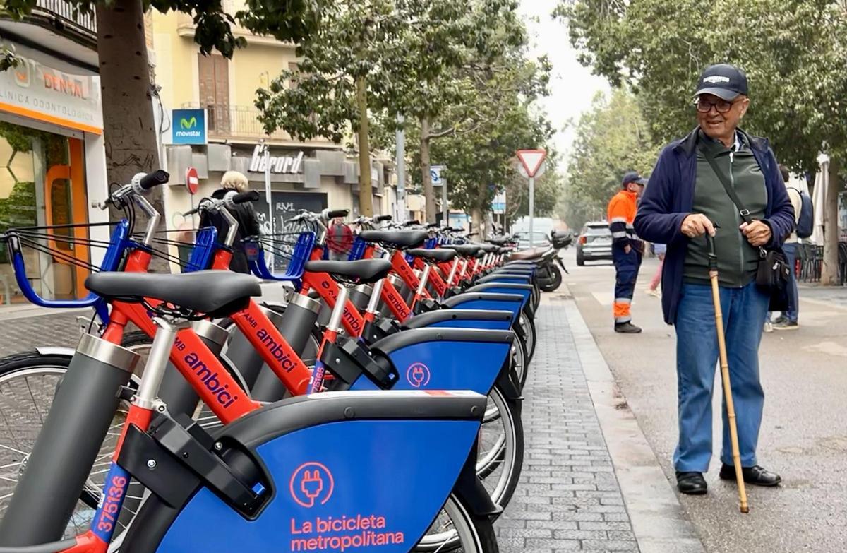 Un vecino de Sant Adrià observa las nuevas bicis del AMBici, este lunes, en la avenida de Catalunya