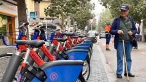 Un vecino de Sant Adrià observa las nuevas bicis del AMBici, este lunes, en la avenida de Catalunya