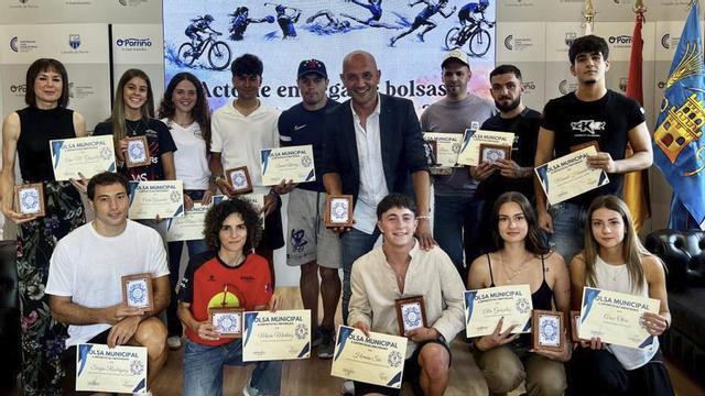 El alcalde posa con trece de los deportistas que lograron la ayuda. | D.P.
