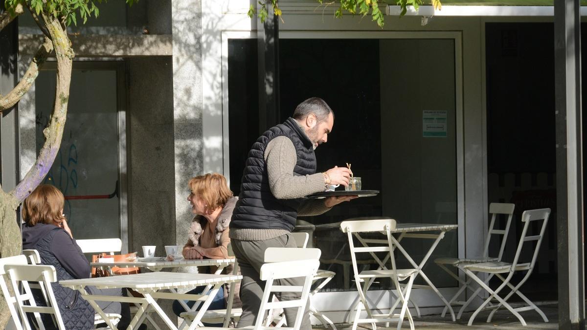 Un camarero, en una terraza semivacía en Bueu