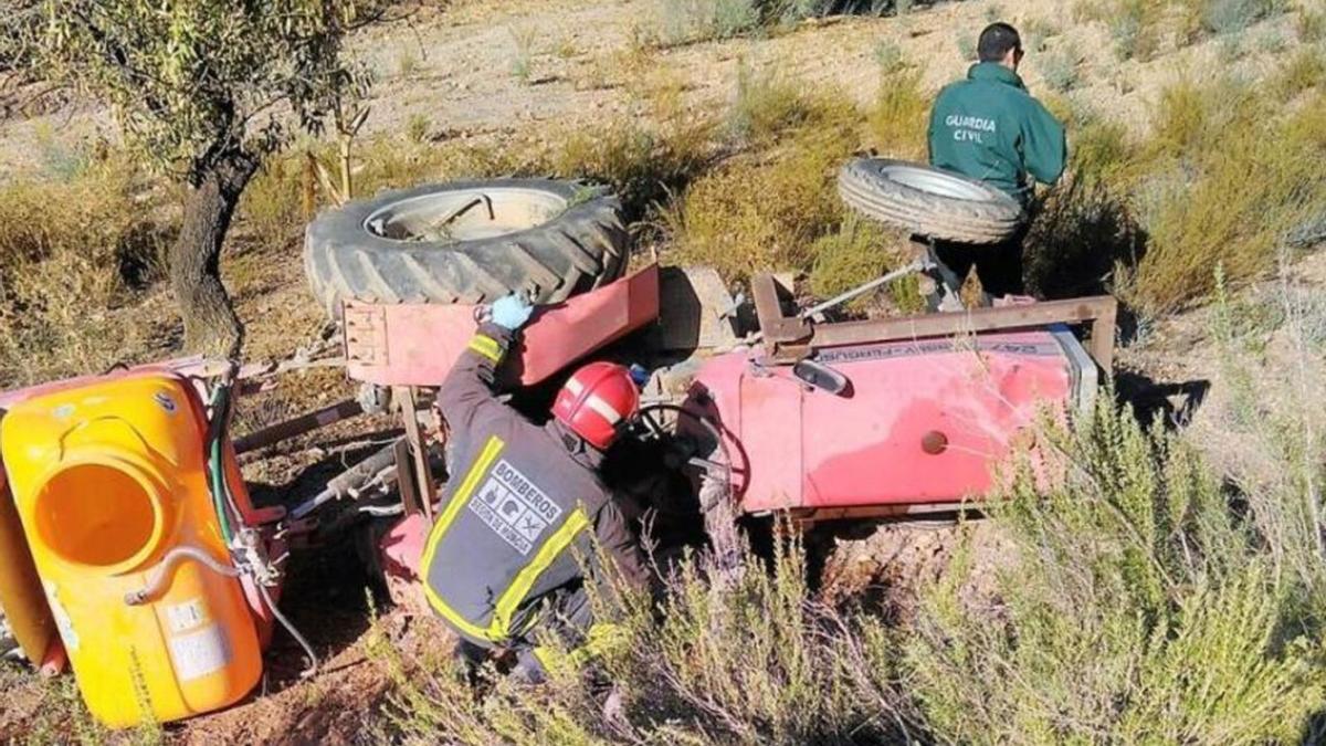 Un bombero revisa el tractor en el que un trabajador del campo murió al caerle encima el vehículo (archivo).