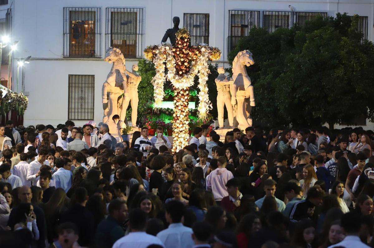 Multitud de jóvenes en la Cruz de Mayo instalada en plaza Conde de Priego.