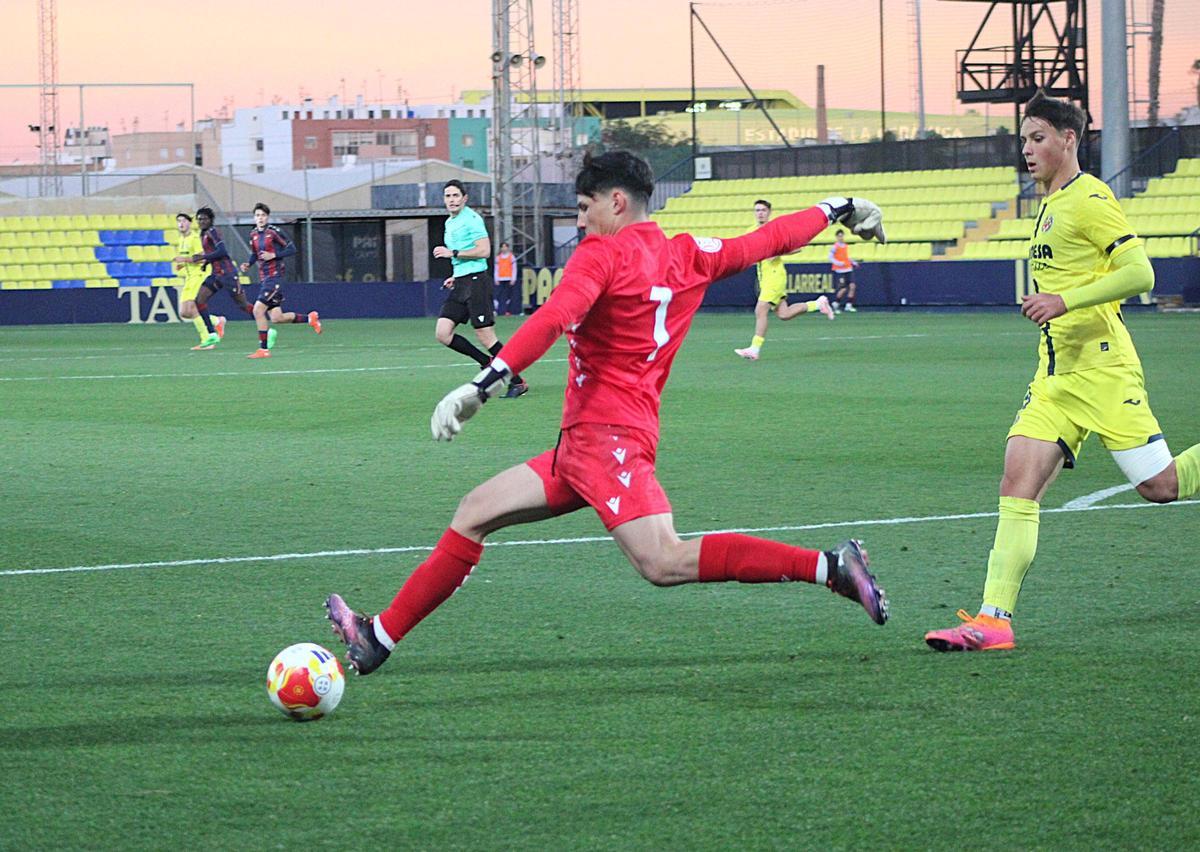 Adri Ruiz, portero del Levante juvenil, despeja un balón ante la mirada de Julio Arjona.
