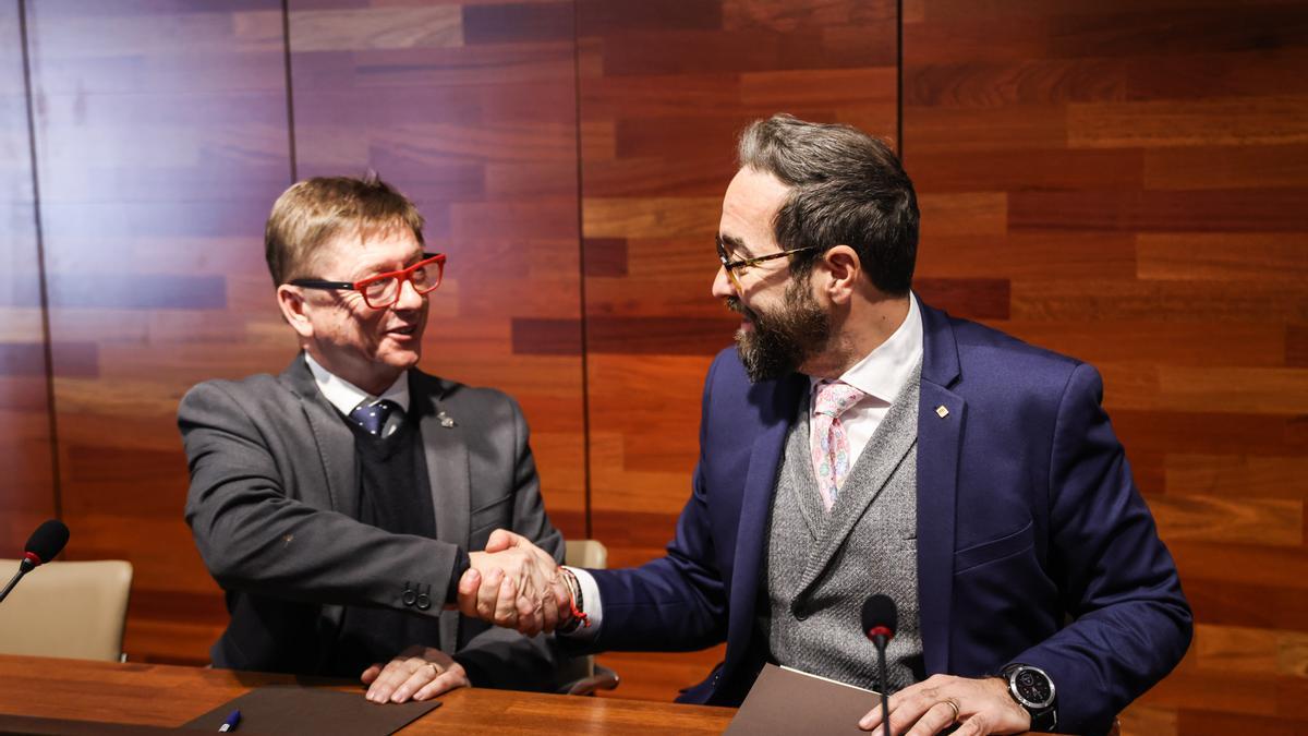 El conseller de Territori, Juli Fernández, i l'alcalde de Caldes de Malavella, Salvador Balliu, durant la signatura del conveni per fer la nova rotonda a la GI-673, a l'accés de la urbanització Llac del Cigne.