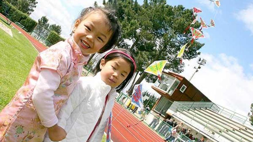 Dos niñas con sus cometas, arriba. A la izquierda, taller de &quot;papaventos&quot;, y sobre estas líneas Xian Fu