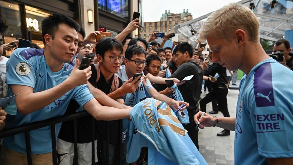 Oleksandr Zinchenko firmando camisetas en China