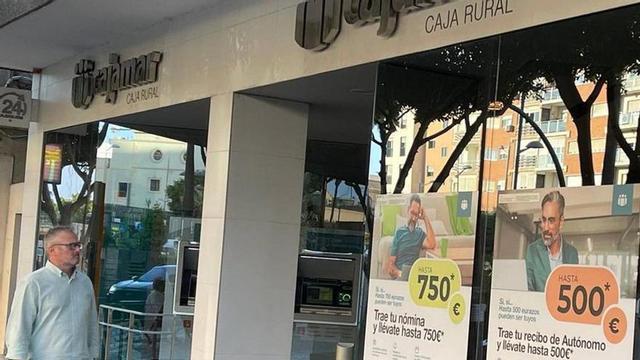 Un hombre pasea frente a una oficina de Cajamar.