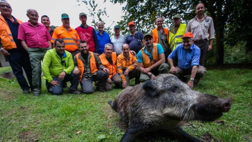 Los integrantes de la cuadrilla de cazadores con el jabalí abatido en el Naranco.