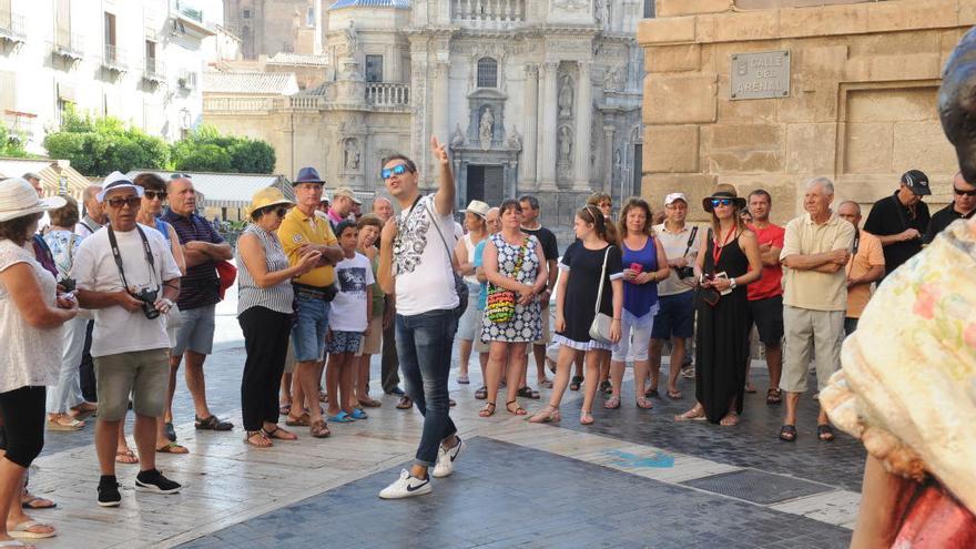 Un grupo de turistas frente a la Oficina de Turismo de Murcia, visitando la Plaza del Cardenal Belluga.