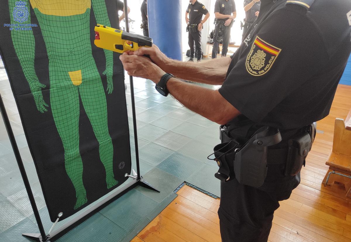 Un agente de la Policía Nacional apunta a un blanco con una pistola táser