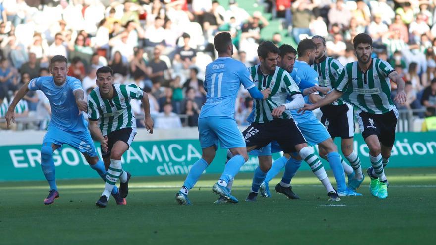 Jugadores de ambos equipos pugnan en una acción dentro del área.