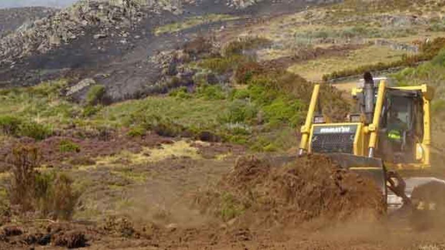 Una máquina trabaja en la zona afectada. Debajo, evolución del incendio a primeras horas de la mañana.