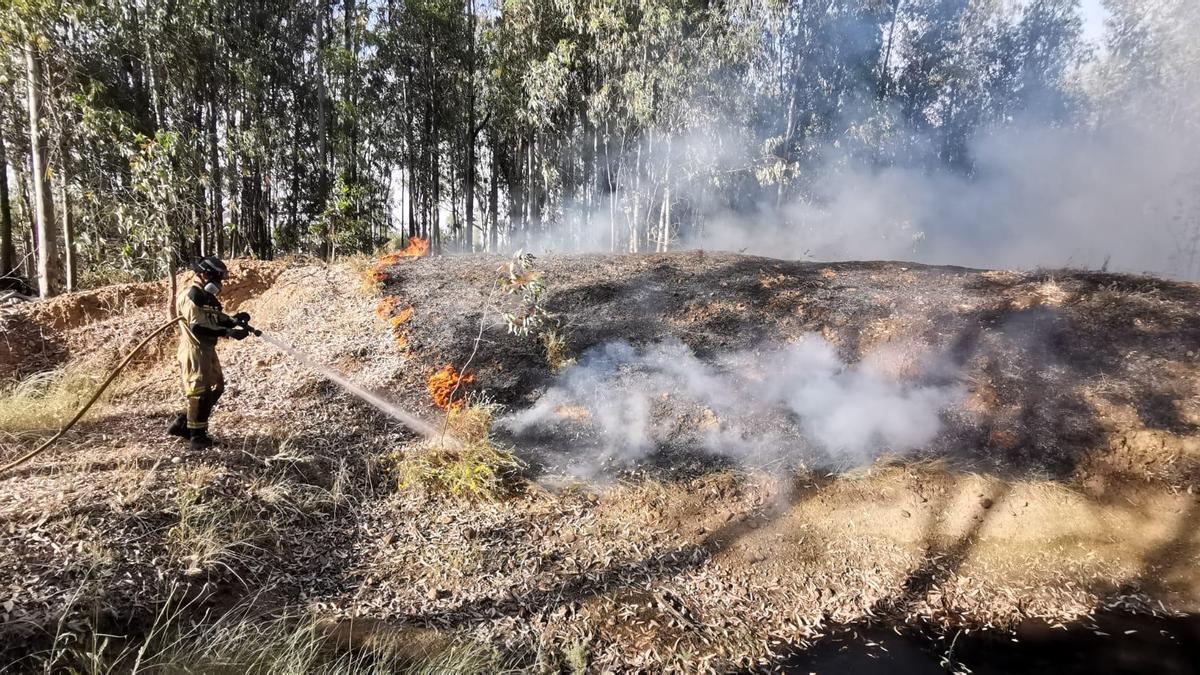 Un bombero trabaja en las tareas de extinción del fuego que se ha declarado junto a El Faro.