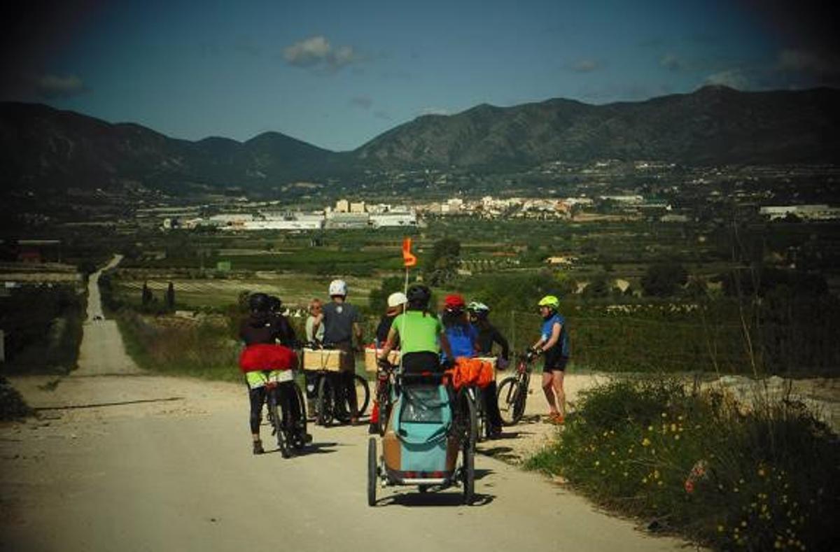 Un grupo de turistas en bicicleta por un sendero de la Vall d'Albaida.