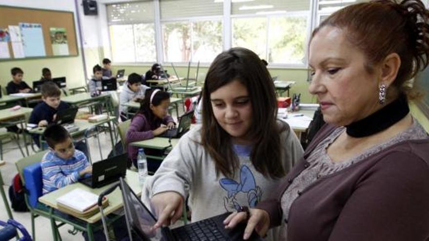La profesora de sexto del Narciso Yepes de Murcia mira el trabajo hecho en el ordenador por una de sus alumnas.