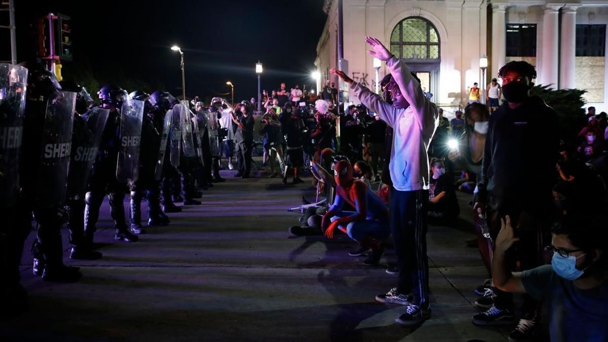 Manifestantes se encaran con la policía durante las protestas contra la violencia racial, la pasada madrugada en Kenosha.