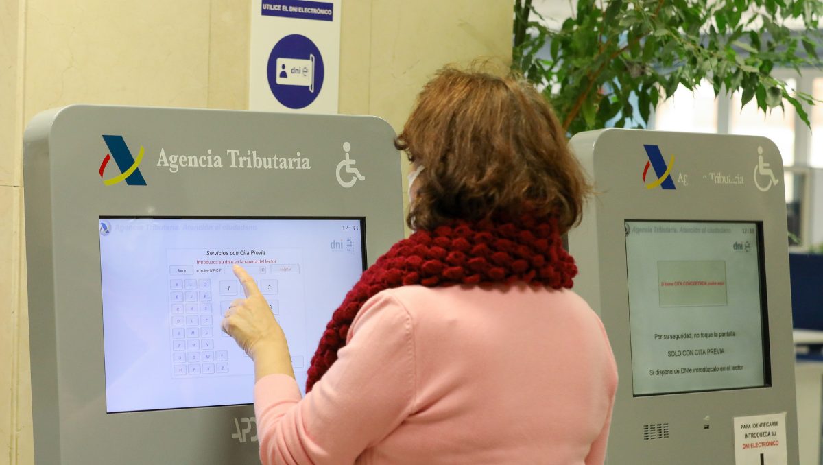 Una mujer recoge su turno en una oficina de la Agencia Tributaria, este martes, en Madrid.