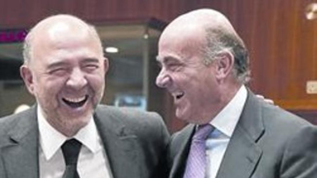 Moscovici, a la izquierda, y Guindos bromean antes de la reunión del Ecofin.