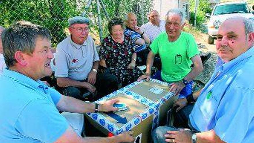 Un nutrido grupo de mayores se reúne cada tarde en una esquina del barrio de A Cuña para jugar a las cartas.  / jesús regal