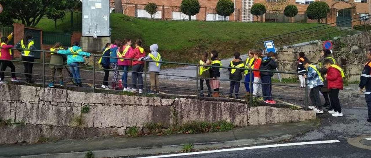 Niños con sus petos de seguridad, en la salida de campo para recorrer el trazado del camino. // S.Á.