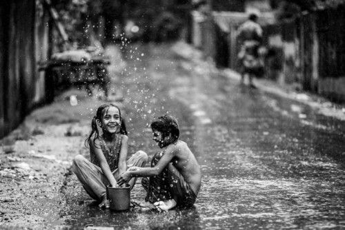 Dos jovenes de una barriada en Bangladesh disfrutan en la lluvia