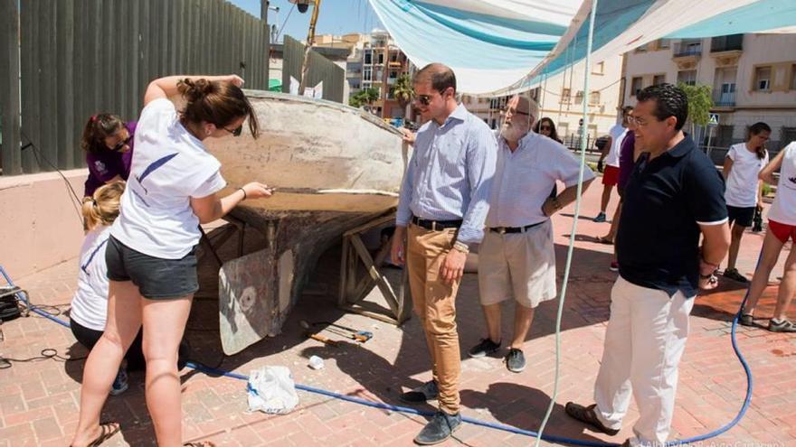 Voluntarios restaurando una barca de vela latina