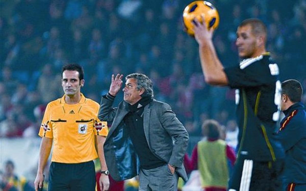 José Mourinho dóna instruccions a l’equip, davant de Benzema, en el partit d’ahir del Madrid a Almeria.