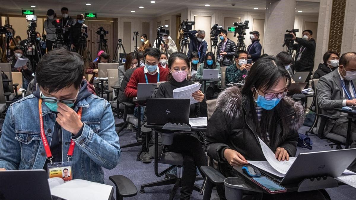 Periodistas con mascarilla atienden una rueda de prensa en Pekín, este lunes.