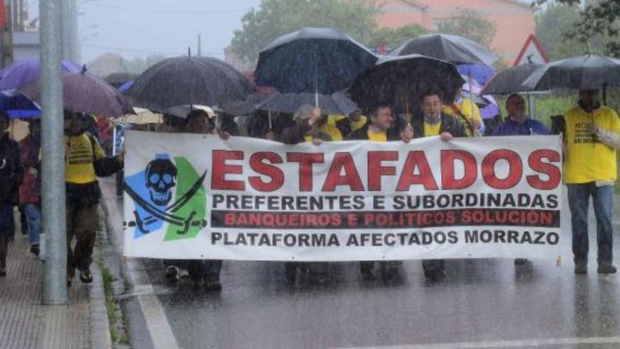 Afectados de la plataforma de Moaña bajo la intensa lluvia durante la ruta reivindicativa a su paso por Tirán.  // Gonzalo Núñez