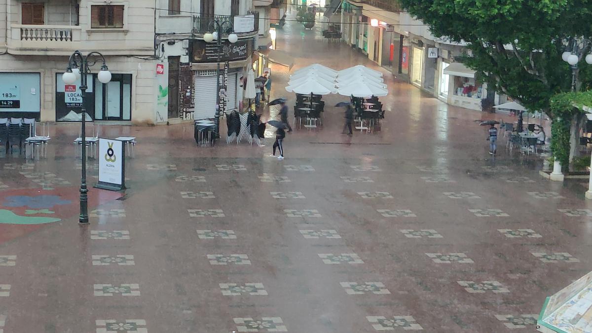 La lluvia deja vacía la Plaça Major de Alzira.