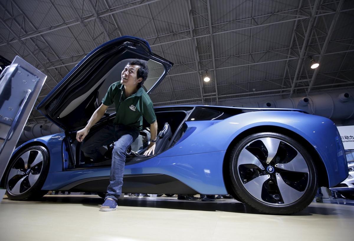 Un visitante sale del nuevo deportivo BMW i8 híbrido, en el estand de la firma en la Salón del Automóvil de Pekín.