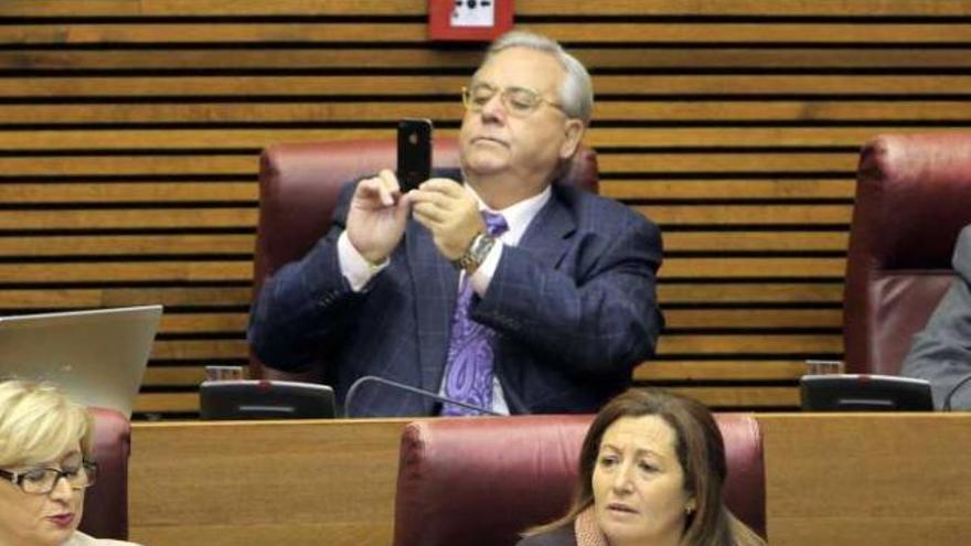 Luis Díaz Alperi graba con su móvil la toma de posesión de su hija como diputada.