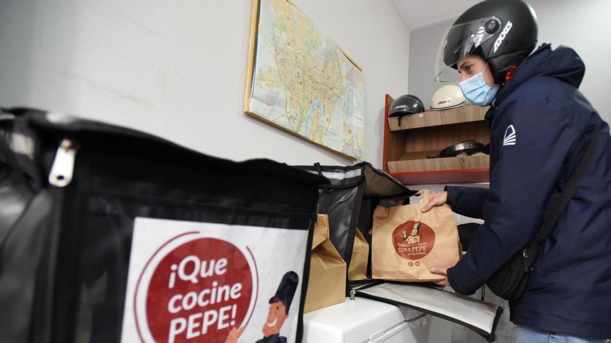 El repartidor de una empresa se prepara para realizar una entrega de comida a domicilio.