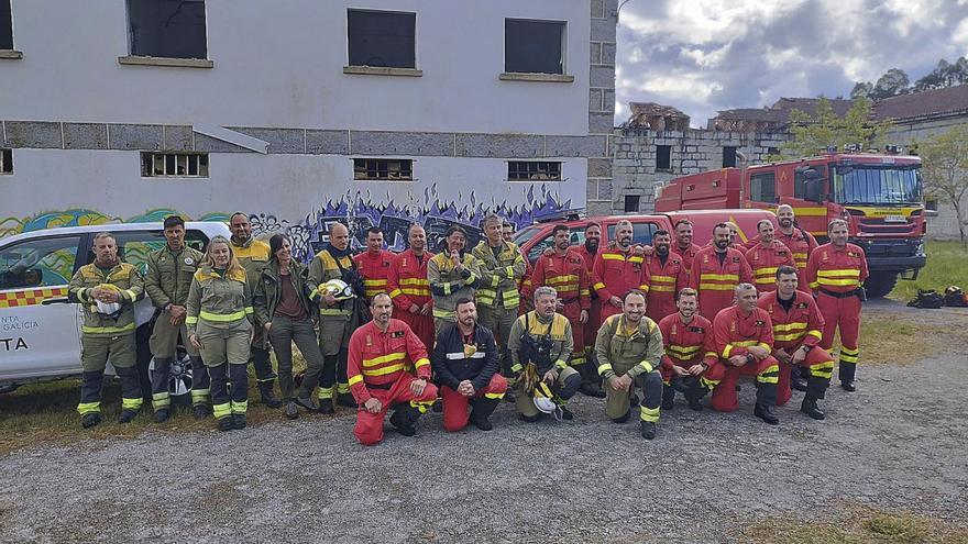 Profesionales de incendios de Galicia y militares de la UME, en el centro de Toén.   | // I.O.