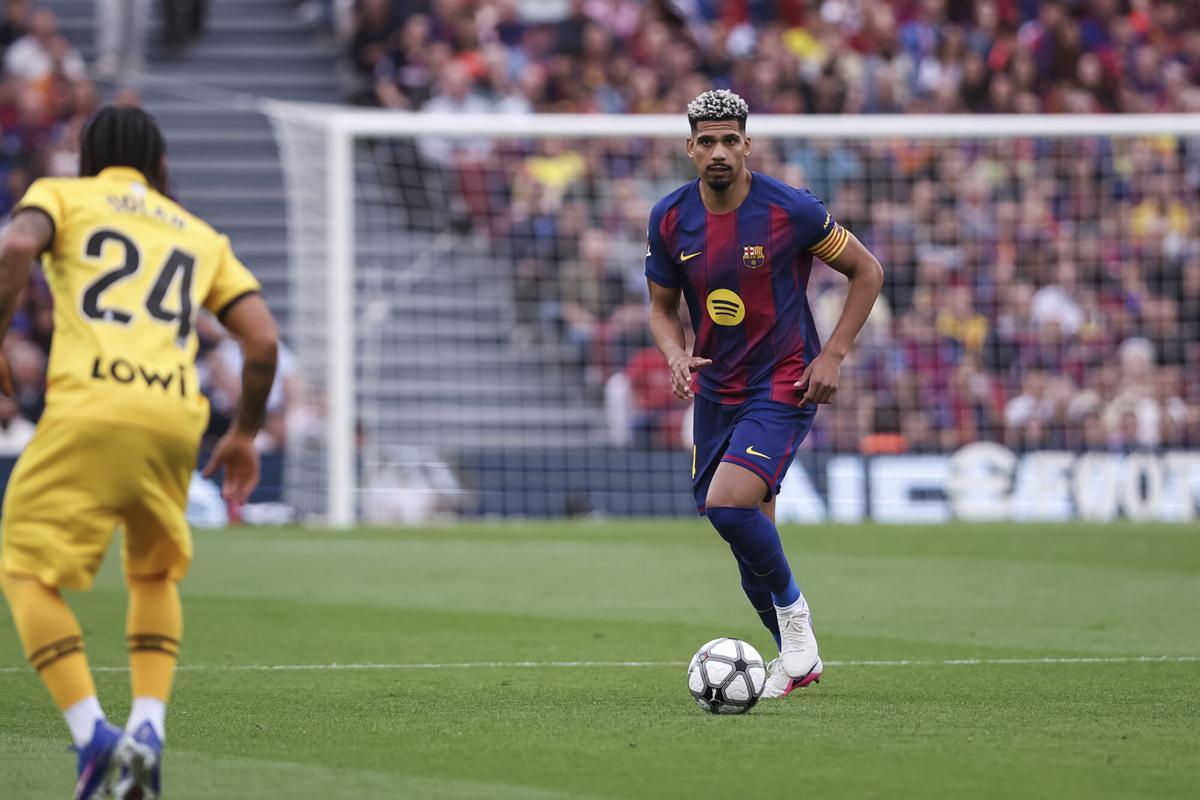 Araujo, con el brazalete de capitán, conduce el balón.