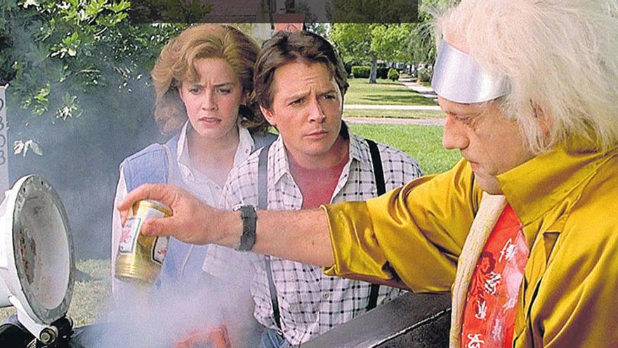 Imagen de la película &#039;Regreso al futuro II&#039; en el momento que Emmett Brown introduce basura en su DeLorean ante la mirada perpleja de Marty McFly y su novia.