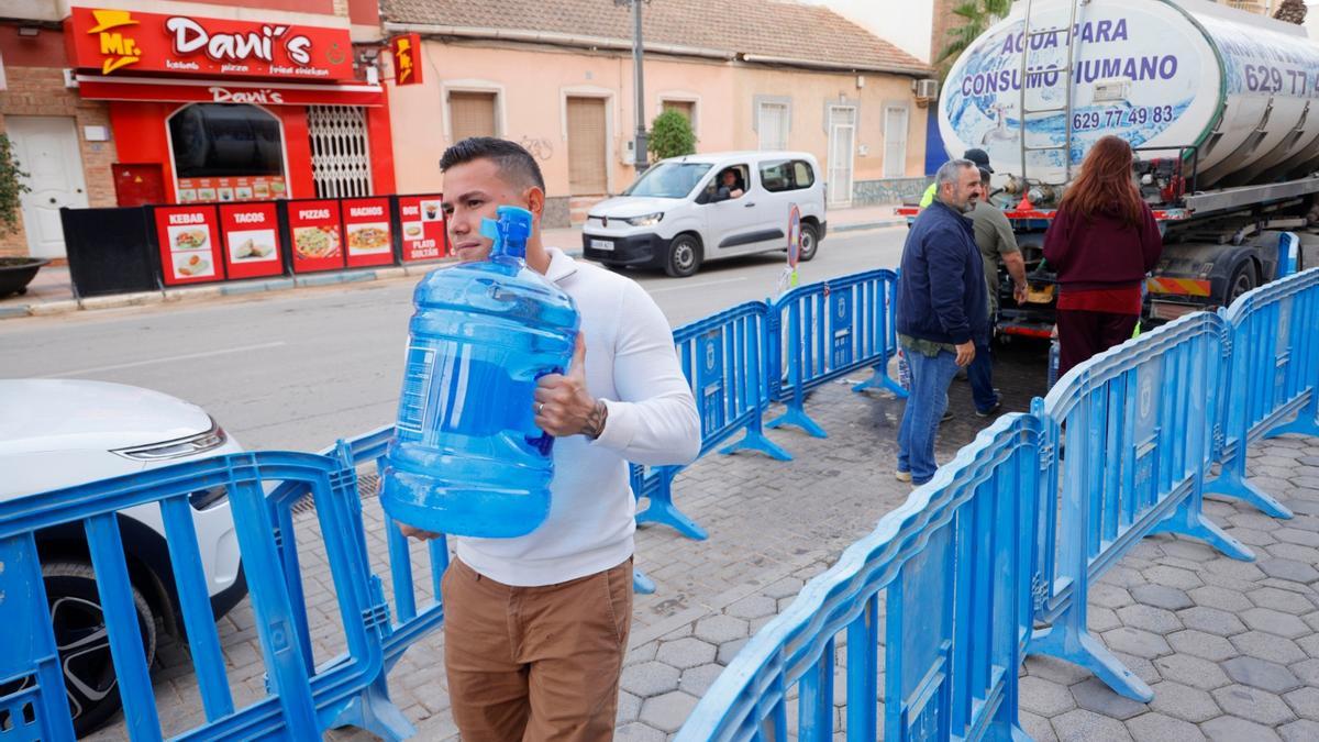 Vecinos de Los Alcázares rellenando botellas de agua durante el corte de suministro