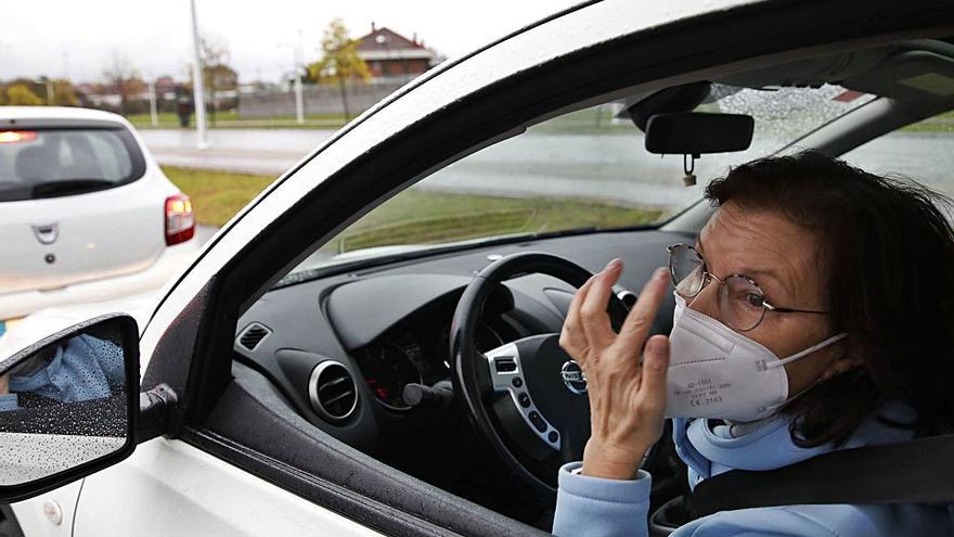 La gijonesa Nieves Suárez, ayer, en su vehículo, en la cola del autocovid del aparcamiento de la Escuela de Marina de Gijón. | Ángel González