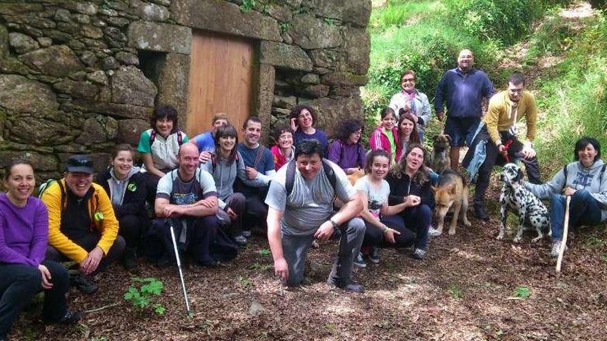 Arriba, los participantes en la Ruta dos Carreiros de Ouzande A la derecha, paso de los caminantes por la zona  de los molinos.