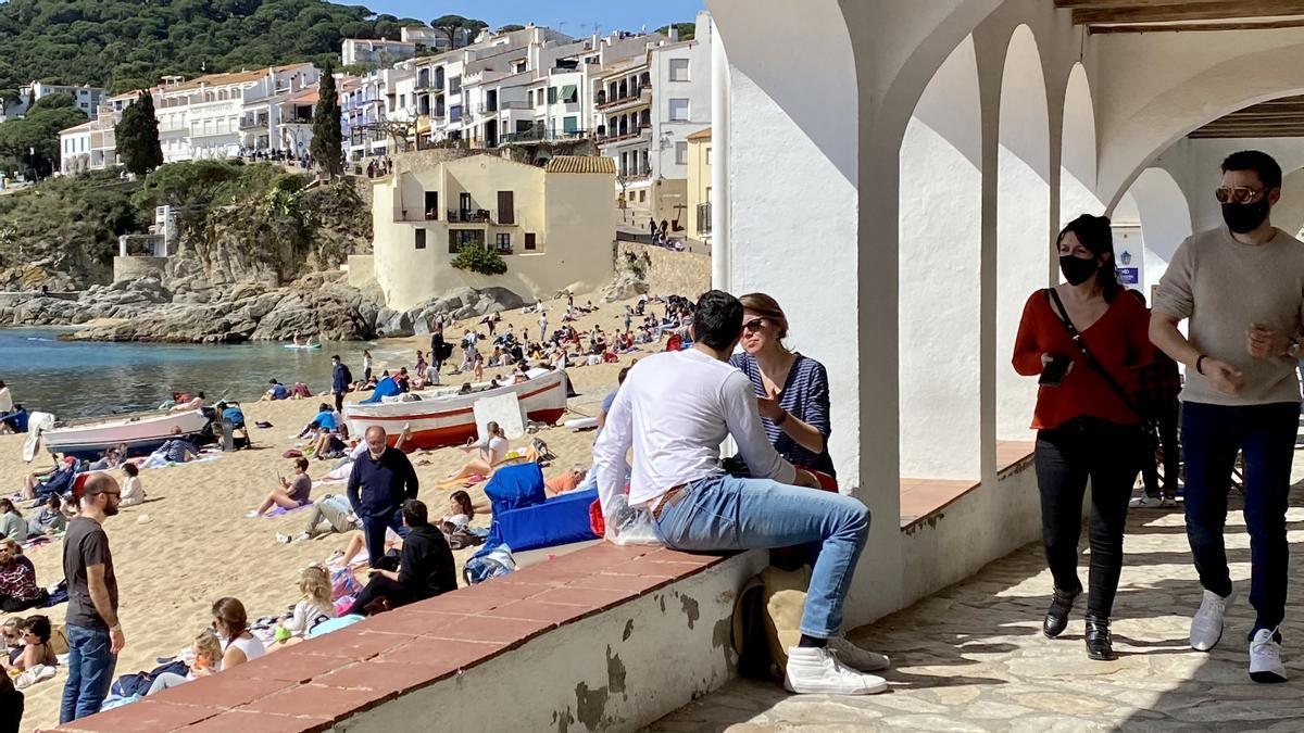 'Les voltes' de Calella de Palafrugell, con gente paseando o disfrutando del sol en la playa, este domingo