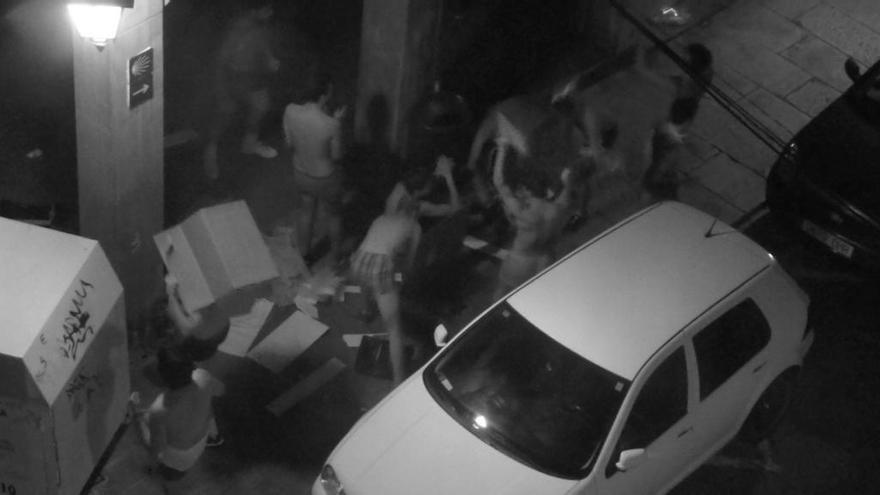 Captura a través de móvil de los jóvenes provocando destrozos en la puerta de la residencia femenina.