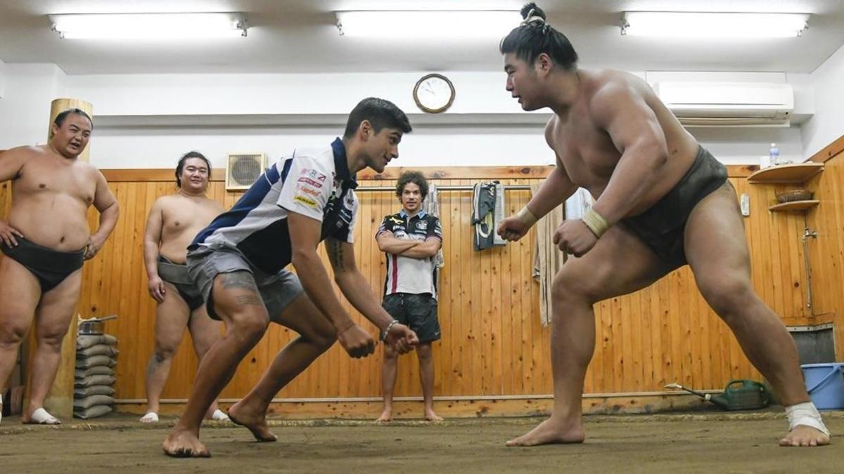 Jorge Martin, lider de Moto3, saluda e intenta enfrentarse (en broma) a un luchador de sumo, hoy, en Tokio.