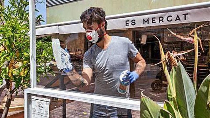 Un trabajador limpia una mampara de Es Mercat durante la mañana de ayer.