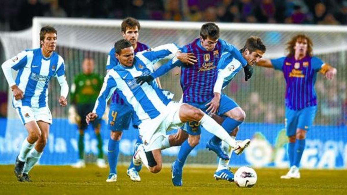 Cuenca intenta superar a dos jugadores de la Real, en el partido de ayer en el Camp Nou.