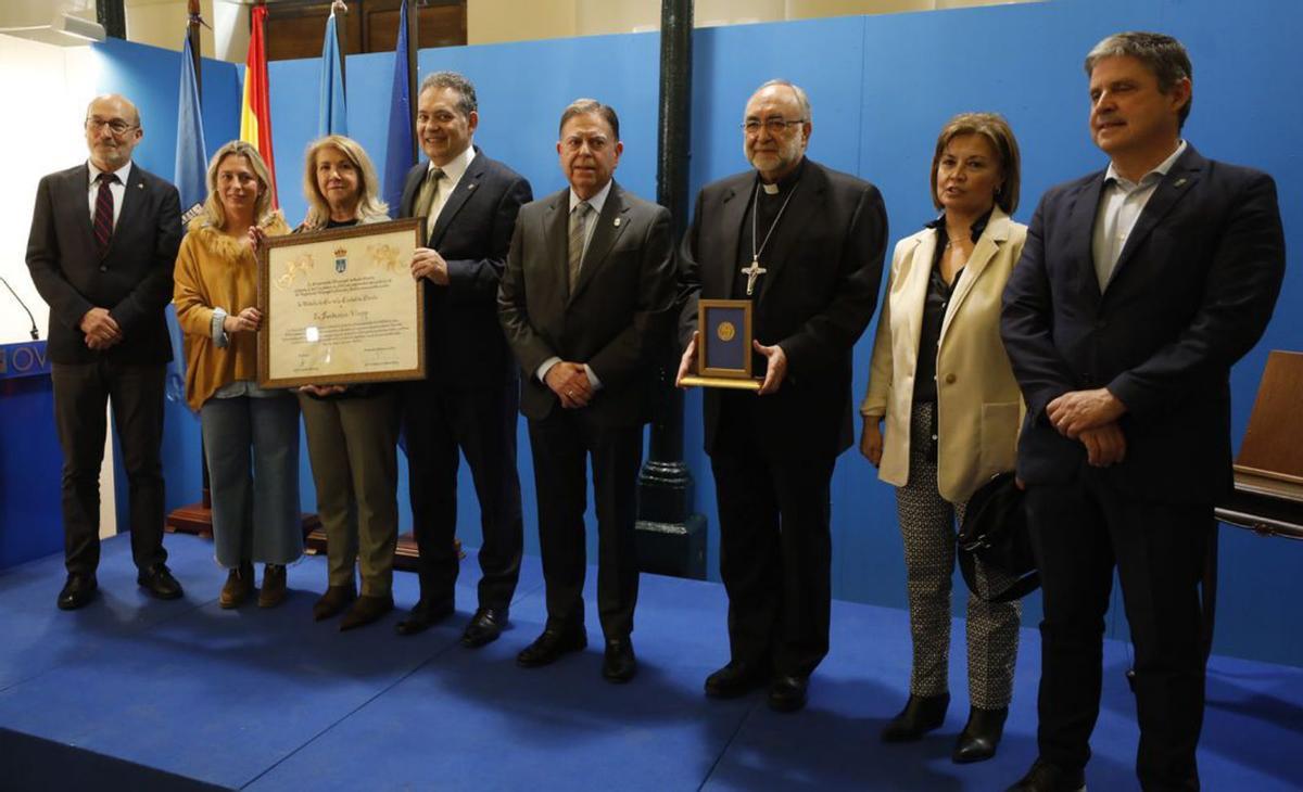 Por la izquierda, Jesús Porfirio Álvarez, Reyes Fernández Hurlé, Celia Fernández, Adolfo Rivas, Alfredo Canteli, Jesús Sanz Montes, María Esther Fernández y Enrique Rodríguez Nuño, posando ayer en la plaza de Trascorrales con la Medalla de Oro de la ciudad y el diploma acreditativo de la máxima distinción municipal.