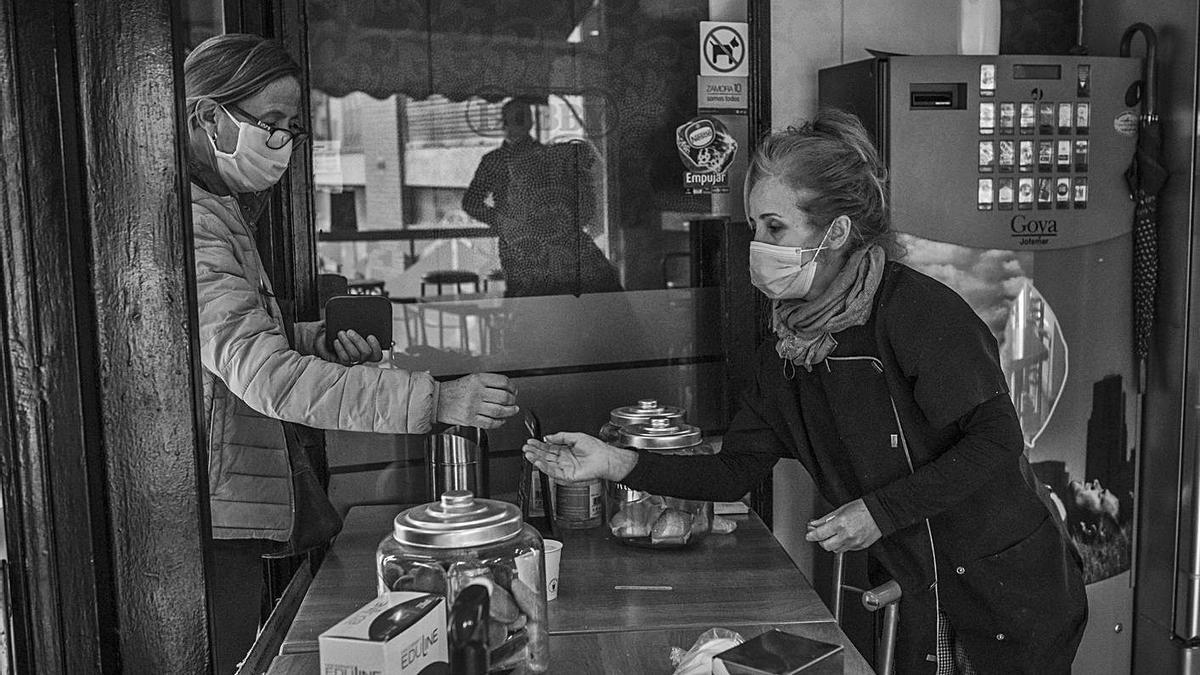 Marga Pires sirve un café para llevar a una clienta. | Emilio Fraile